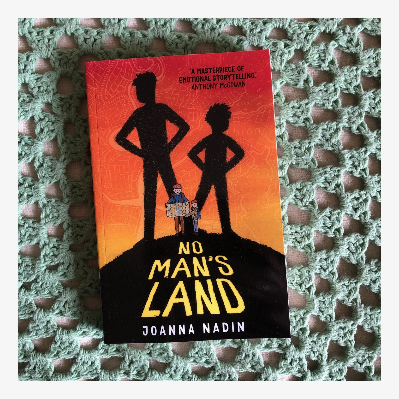 Book cover featuring two small books lost on a hill. Their shadows behind them are in superhero stance.